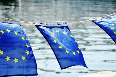 European union flags tied on rope waving by sea