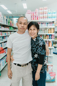 Portrait of couple standing at supermarket