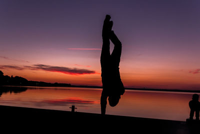 Silhouette of people in sea at sunset