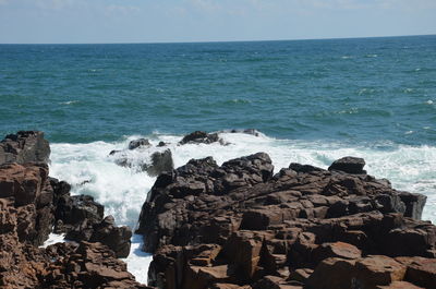 Panoramic shot of rocks on sea against sky