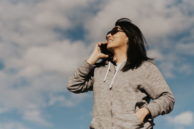 Low angle view of woman standing against sky