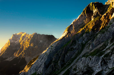 Low angle view of mountains against clear blue sky