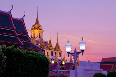 Illuminated building against sky at dusk