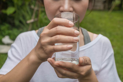 Midsection of woman drinking water