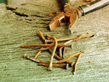 Close-up of old rusty pliers and nails on wooden table