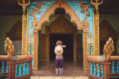 Rear view of woman standing at temple