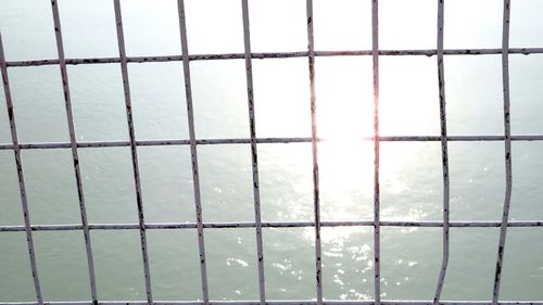 Close-up of sky seen through chainlink fence