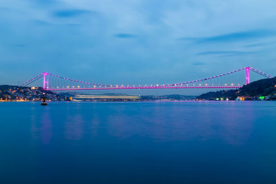 View of bridge over river at night