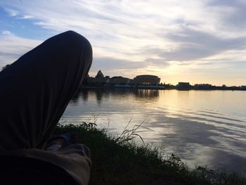 Low section of man on river against sky