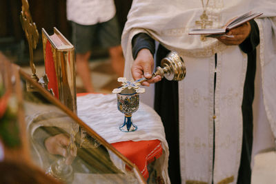 Midsection of people in wineglass on table