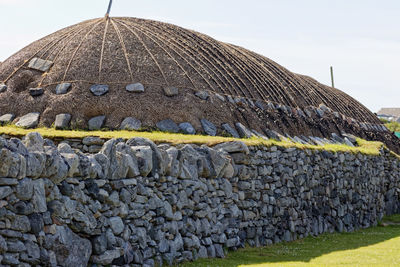 Stone wall of building against sky