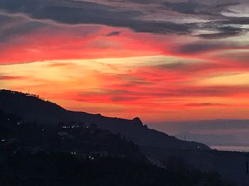 Scenic view of dramatic sky over silhouette landscape