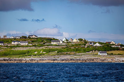 Scenic view of sea by townscape against sky, houses, coastline and old ruined 15th century castle