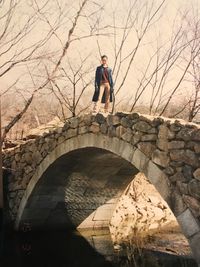 Full length of woman standing on arch bridge