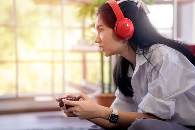 Side view of young woman using mobile phone