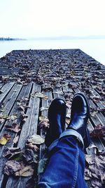 Low section of man standing on beach against clear sky