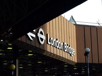 Low angle view of information sign against sky