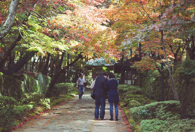 Rear view of people walking on footpath