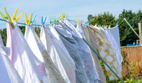 Close-up of clothes drying on clothesline against sky