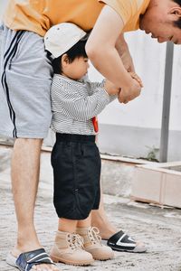 Low section of man tying shoelace