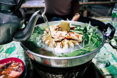 Close-up of meat in pan on charcoal stove