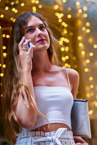 Portrait of a beautiful young woman looking away at night