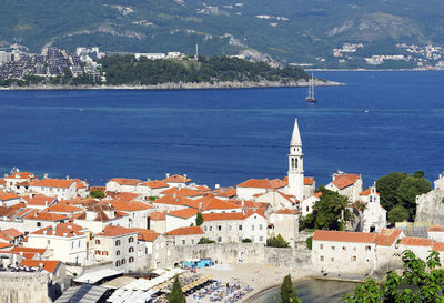 High angle view of town by sea against sky