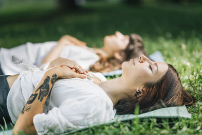 Meditation by the water. two young women lying by the water and meditating