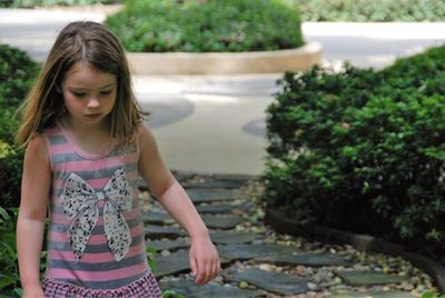 Cute girl standing on footpath