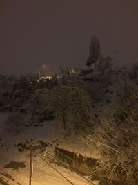 Scenic view of snow covered land against sky at night