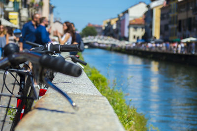 Close-up of bicycle by river in city