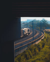 Train by railroad tracks in city against sky