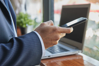 Midsection of man using mobile phone