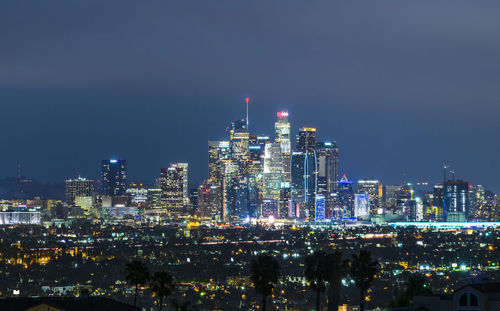 Illuminated cityscape against sky at night