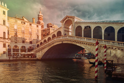 Low angle view of rialto bridge over grand canal against cloudy sky