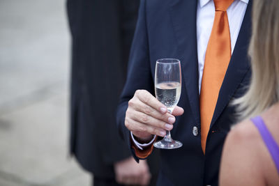 Midsection of man holding drink at event