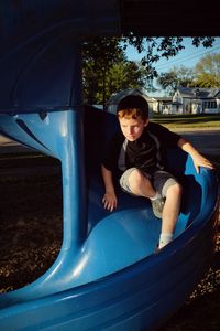 Full length of boy on blue slide at park during sunny day