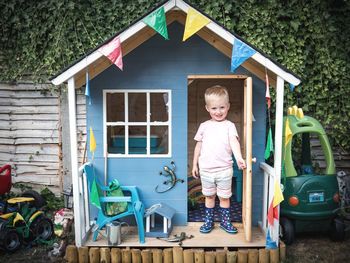 Portrait of cute boy standing in playhouse