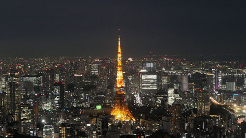 Illuminated cityscape against sky at night