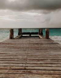 Wooden pier on sea against sky