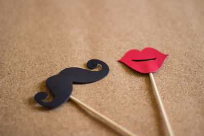 Close-up of artificial mustache and lips on table 