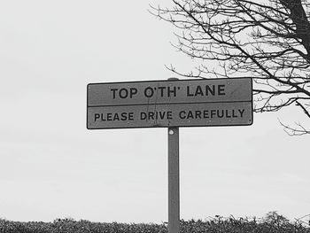 Road sign against sky