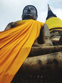 Low angle view of yellow statue against temple