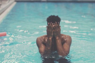 Close-up of shirtless man swimming in pool