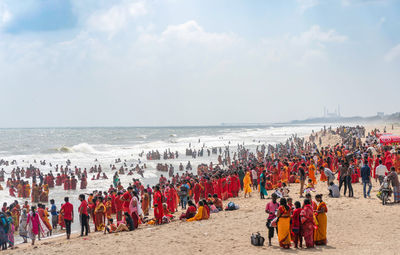 Group of people on beach against sky