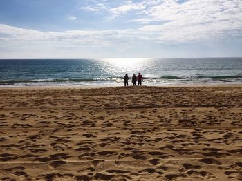 People at beach against sky