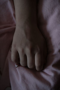 Close-up of woman hand on bed