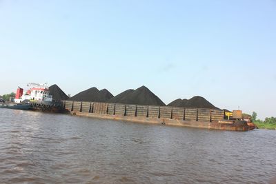 Houses by sea against clear sky