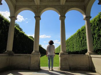 Rear view of woman standing against built structure