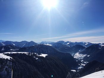 Scenic view of snowcapped mountains against sky on sunny day